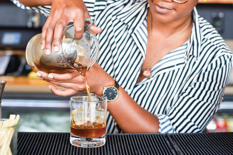 Up-close of someone pouring a mixed drink