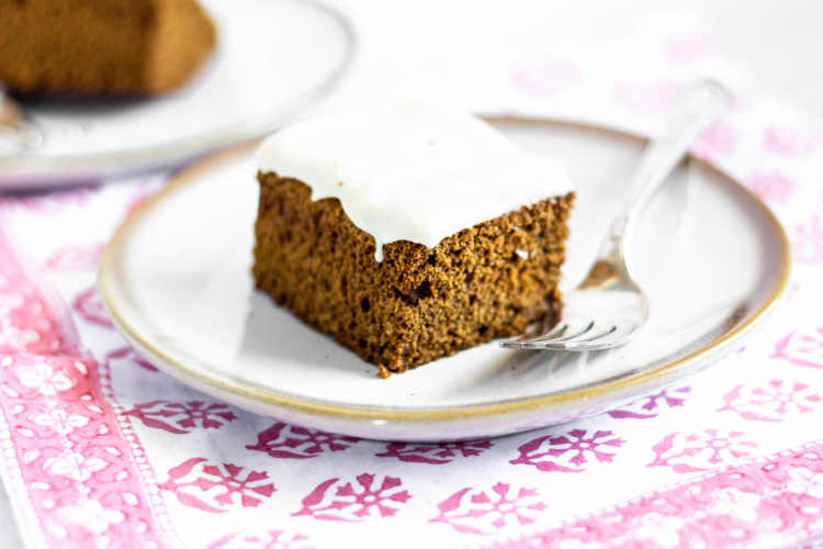 Whole Grain Gingerbread Snack Cake with Cream Cheese Icing on a plate with a fork