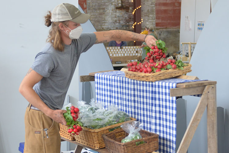 Farmer displays radishes at the Richmond Farmers Market 