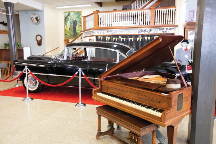 A piano and car that belonged to composer Cole Porters at the Miami County Museum in Peru