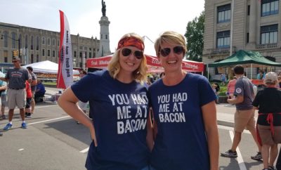 Two women in matching "You had me at bacon" shirts