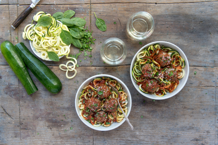 Spinach Herb Meatballs over Zucchini Noodles surrounded by farmers market ingredients