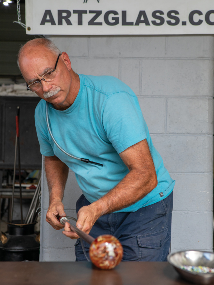 Kenny Zimmerman works on blown glass in his open aired studio