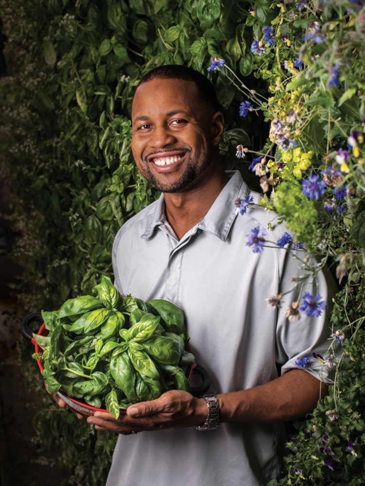 Mario Vitalis, owner and founder of New Age Provisions, holds freshly harvested basil in one of his shipping container gardens
