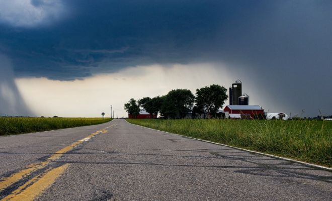 Storm clouds surrounding a house and barn