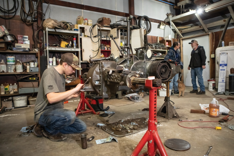Ethan Beebe works on an antique tractor