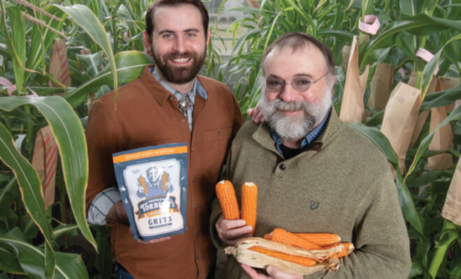 Evan and Torbert Rocheford standing amongst the Orange Corn stalks holding some of the Professor Torbert’s Orange
