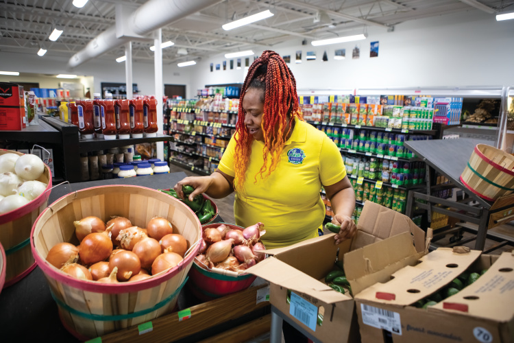 Nicole Green stocks produce at Cleo's Bodega