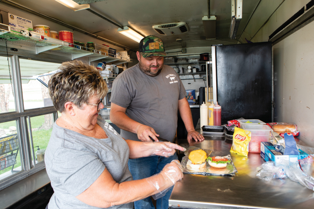 Booby Hayden with his mom cooking inside the food truck
