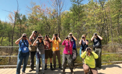 People with binoculars bird watching at the annual Indiana Dunes Birding Festival