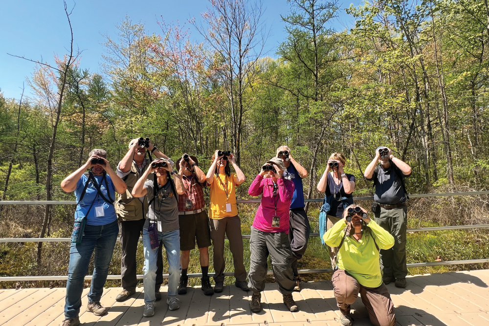 People with binoculars bird watching at the annual Indiana Dunes Birding Festival