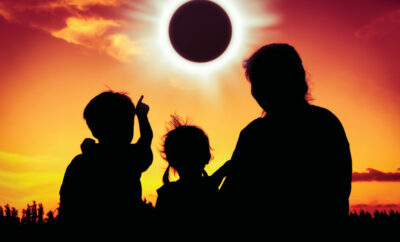 Family silhouetted watching the eclipse
