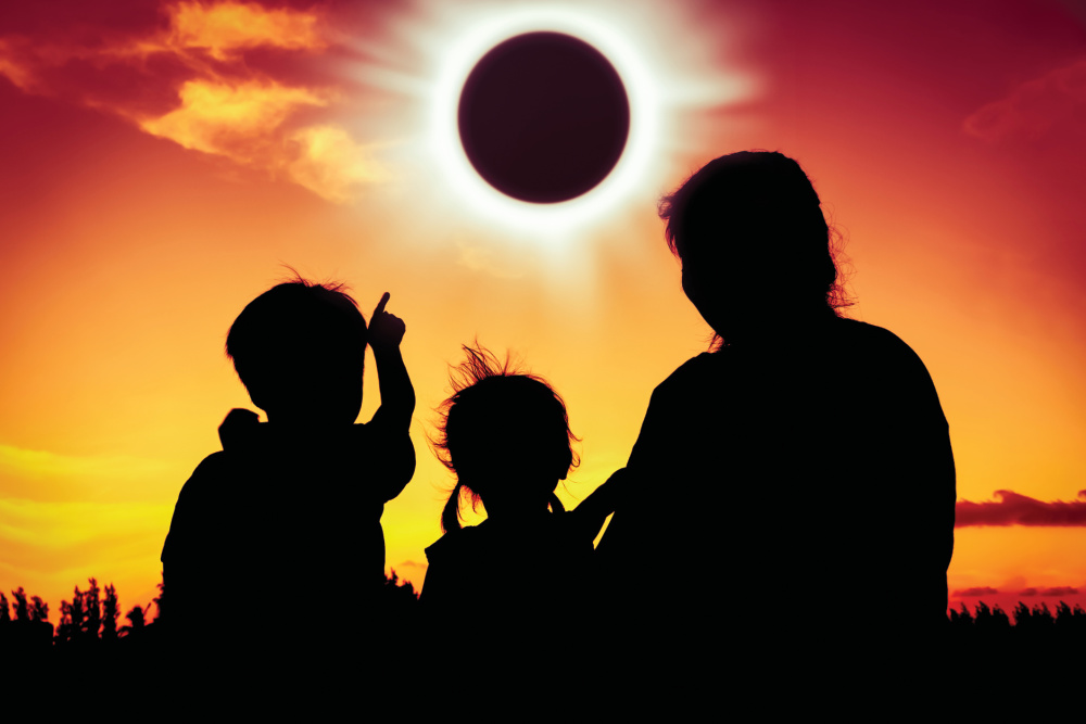 Family silhouetted watching the eclipse