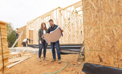 Bree Shroyer and Matt Schickel looking at plans at her house construction site