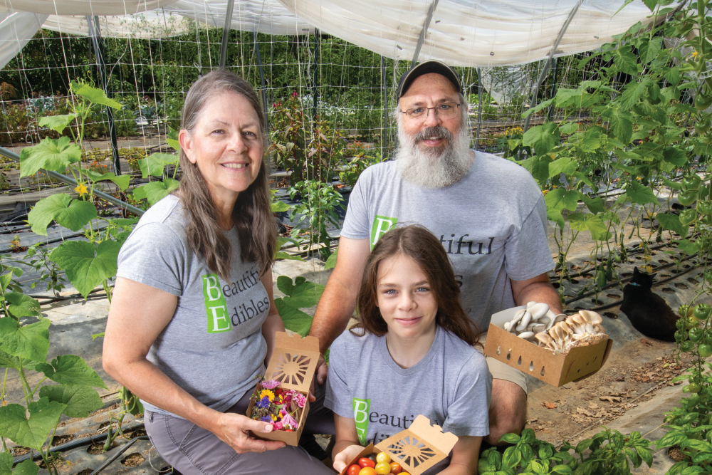 Mary and Roger Winstread with their son Jonathan in a hoop house at Beautiful Edibles