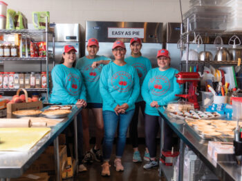 Employees at Be Happy Pie Company pose for a photo in the kitchen