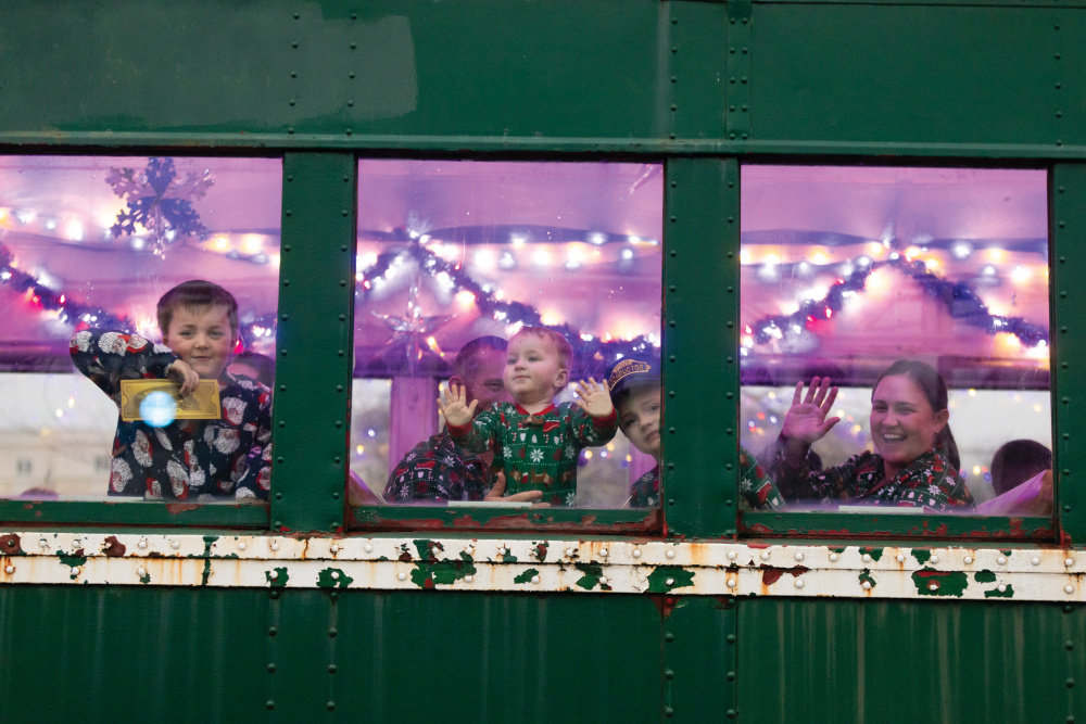 Children in Christmas pajamas looking out the train window