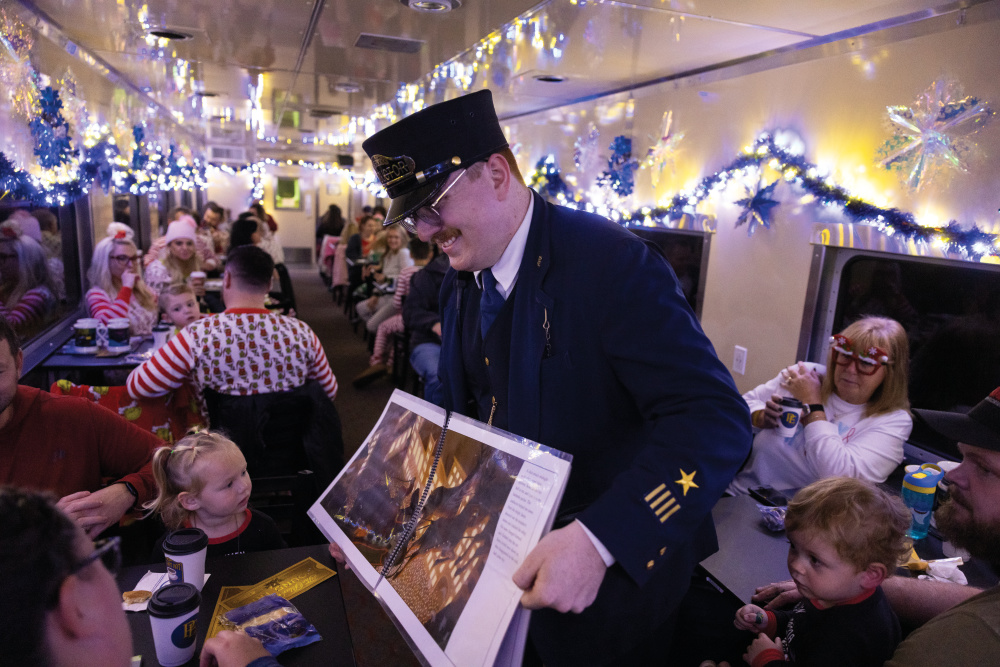 Conductor reading a Polar Express book on the train