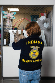 Ayden Huston holding a rabbit wearing her FFA jacket