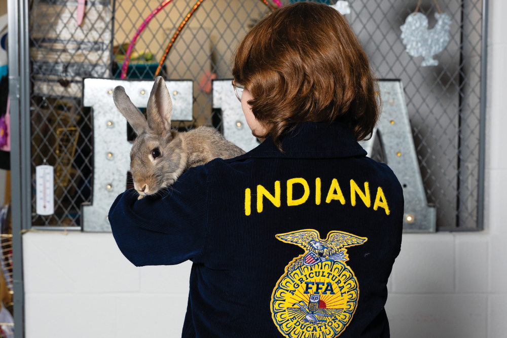 Ayden Huston holding a rabbit wearing her FFA jacket