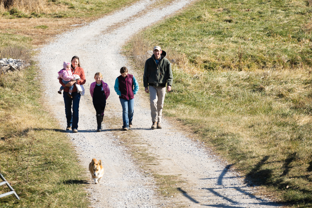 Beth holds her daughter, Grace, as she walks with Hannah, Kate and Nick, down a pathway at LT Farm Meats