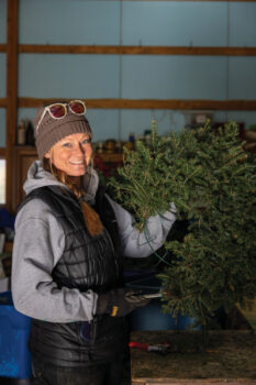 Ashley Ratkovich holds up a wreath she is working on