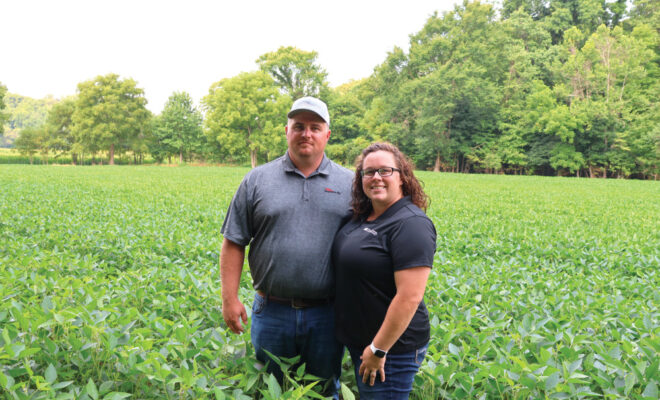 Isaac and Kyla Schroeder in a field at their farm