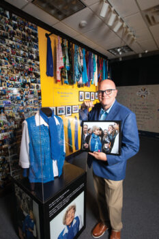 Troy Fears holding a picture of Eva Mozes Kor in one of the CANDLES Holocaust Museum exhibits