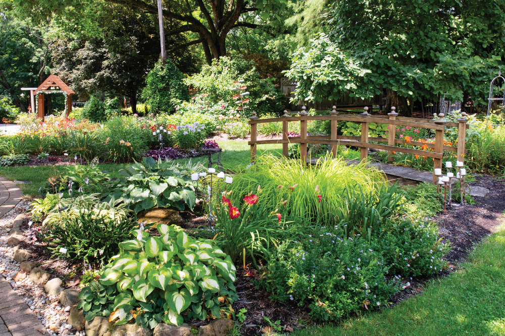 A bridge with flowers and plants surround it at Avon Gardens,