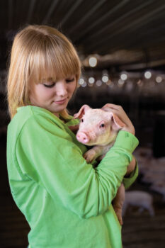 Isabelle Homan holding a piglet 