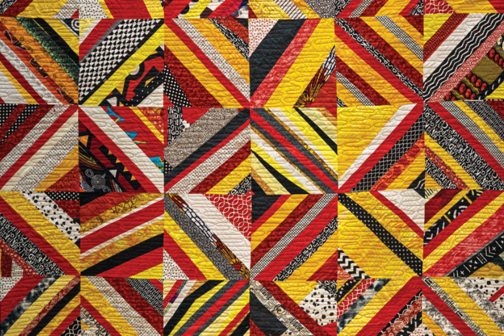 Akoma Ntoso Modern Quilt Guild made quilt comprised of yellow, red, black and white fabric pieces