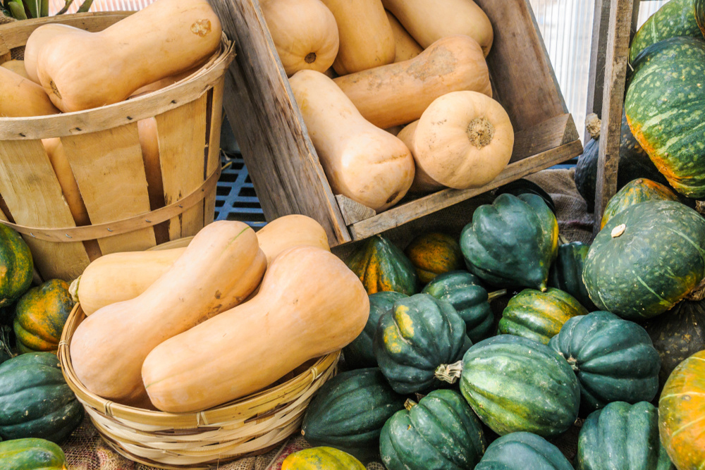 Different types of winter squash in baskets and crates