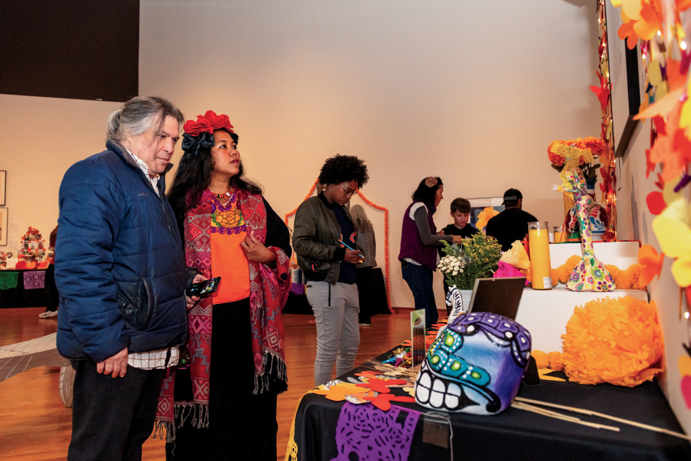 Two people admire one of the ofrendas at the Fort Wayne Museum of Art celebrates Dia de los Muertos