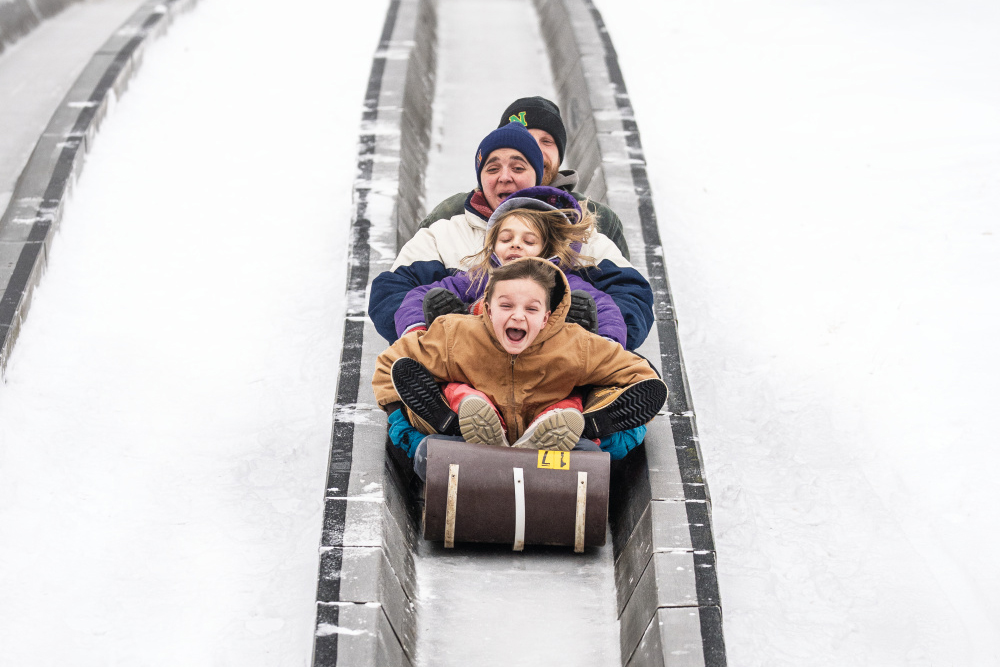 A family of four rides down the Pokagon State Park’s toboggan run, one of the things to do in Steuben County