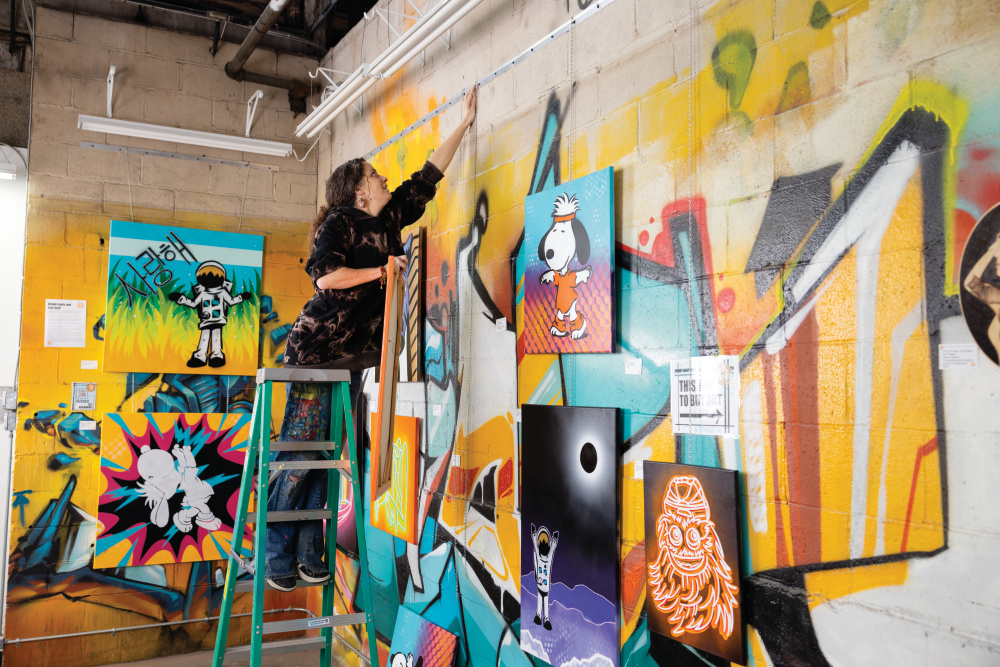 Joy Hernandez hanging some of her artwork at Full Circle Nine Gallery