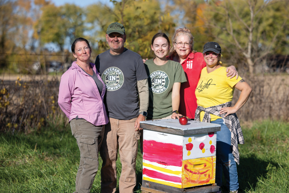 Annette and Joe Ricker with farmhand Christiana Magers and veterans Dawn Marie and Jenn Schumaker pose for a photo next to the beehives