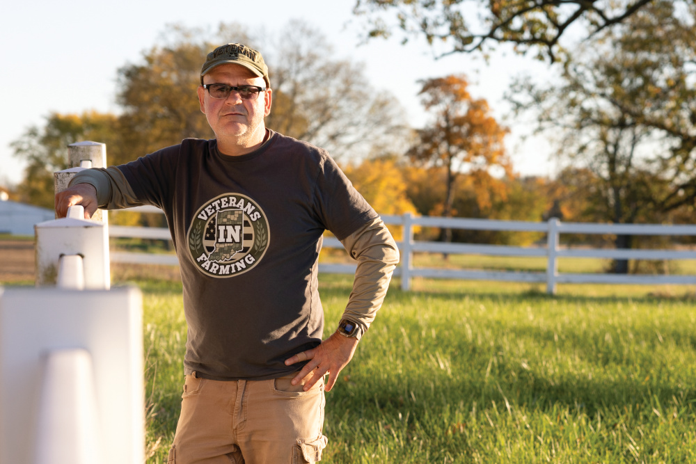 Joe Ricker poses for a photo at his farm, At Ease Orchard