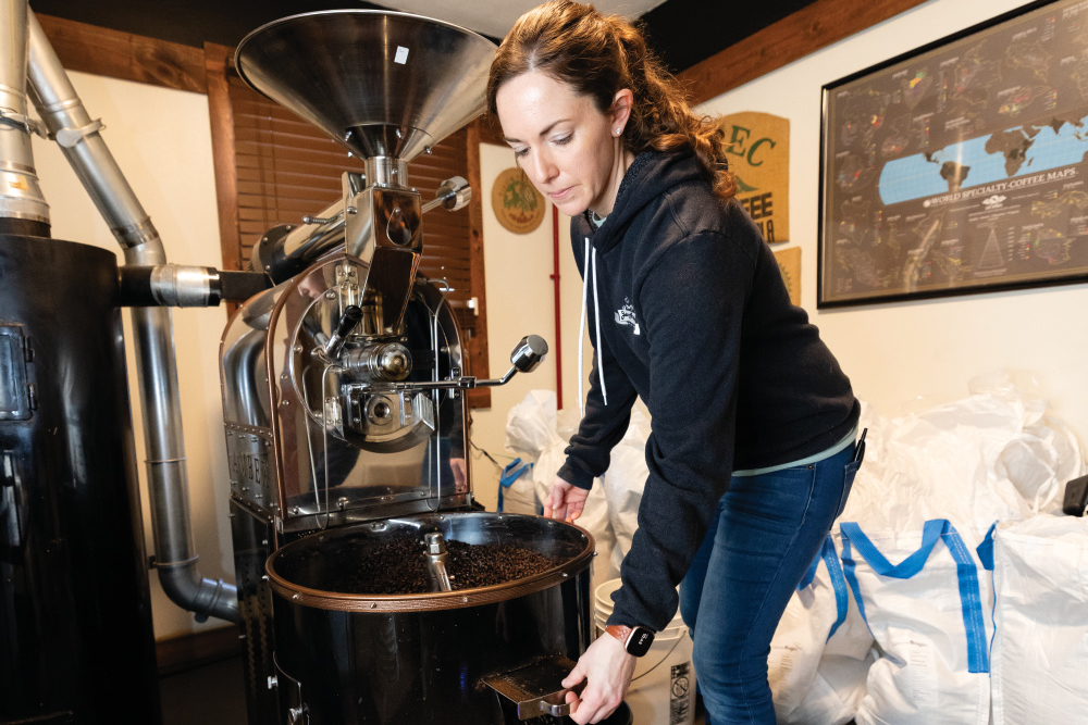 Joana Wade moving freshly roasted coffee beans into a bin