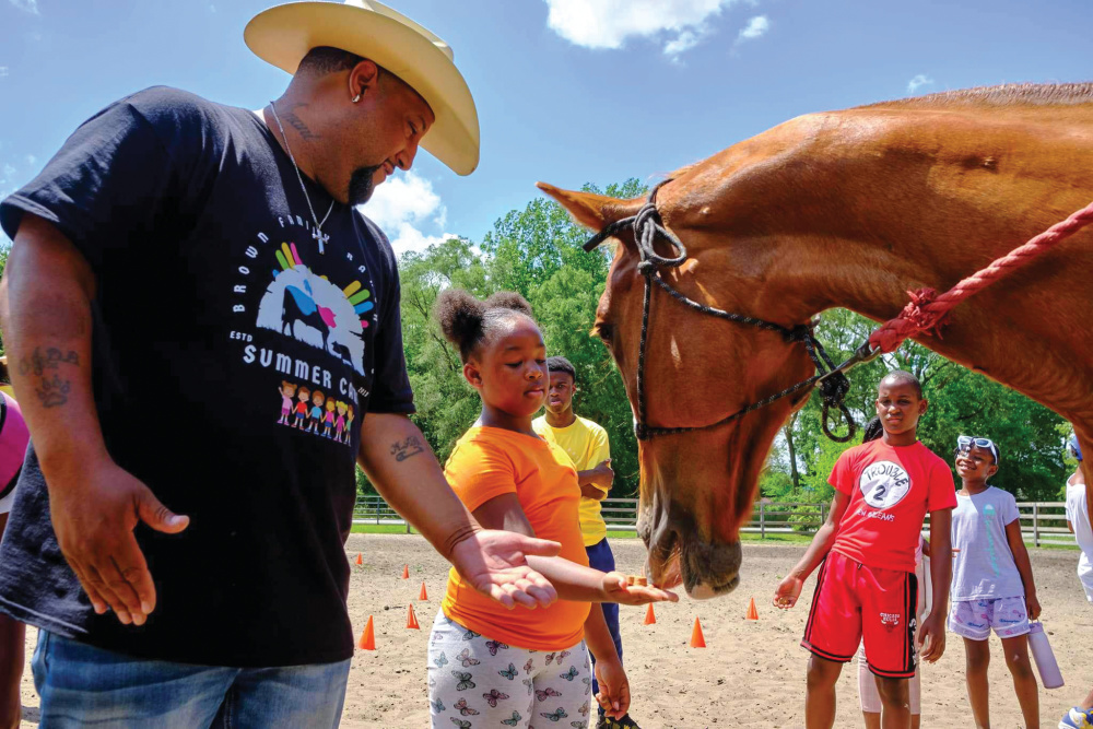 Brown Family Ranch shows a young girl how to feed a horse out of her hand