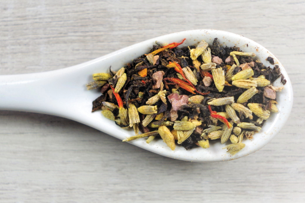 Up-close of Aahaa Chai loose tea in a white spoon