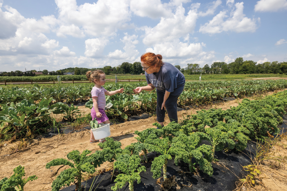 Grandmother and granddaughter picking kale