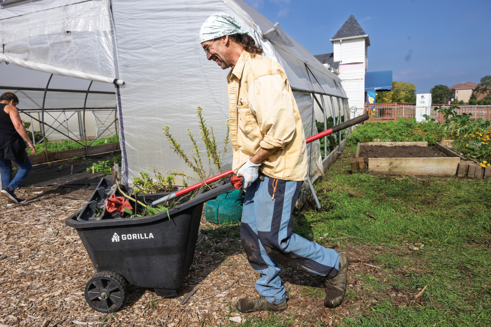 A Faith CDC employee harvesting produce